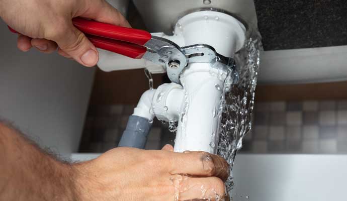 Plumber fixing kitchen plumbing issues