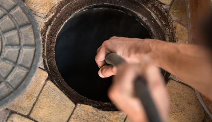 Person cleaning clogged drain