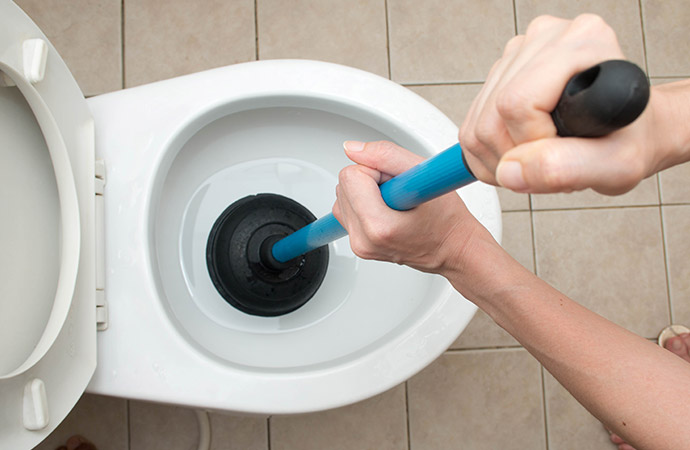 Person repairing toilet