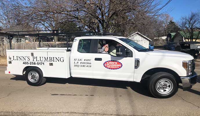 Professional plumber team of LINN'S Plumbing inside van